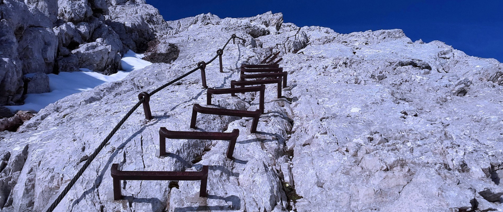 Steile Eisenleiter im felsigen Gebirge – Symbol für herausfordernde Aufstiegsprozesse